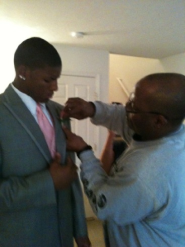 Father and son pinning on flower for dance